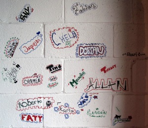 People write their names on the wall of the café